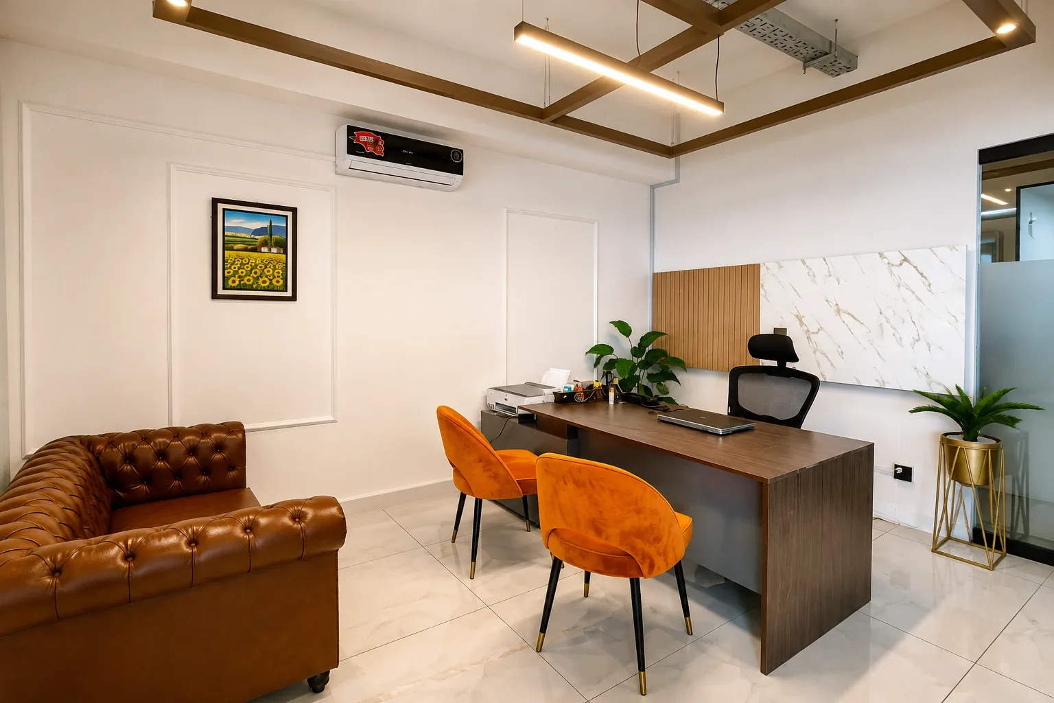 A private SpaceShare Suite: a desk with orange armchairs, a leather sofa and a panelled wall